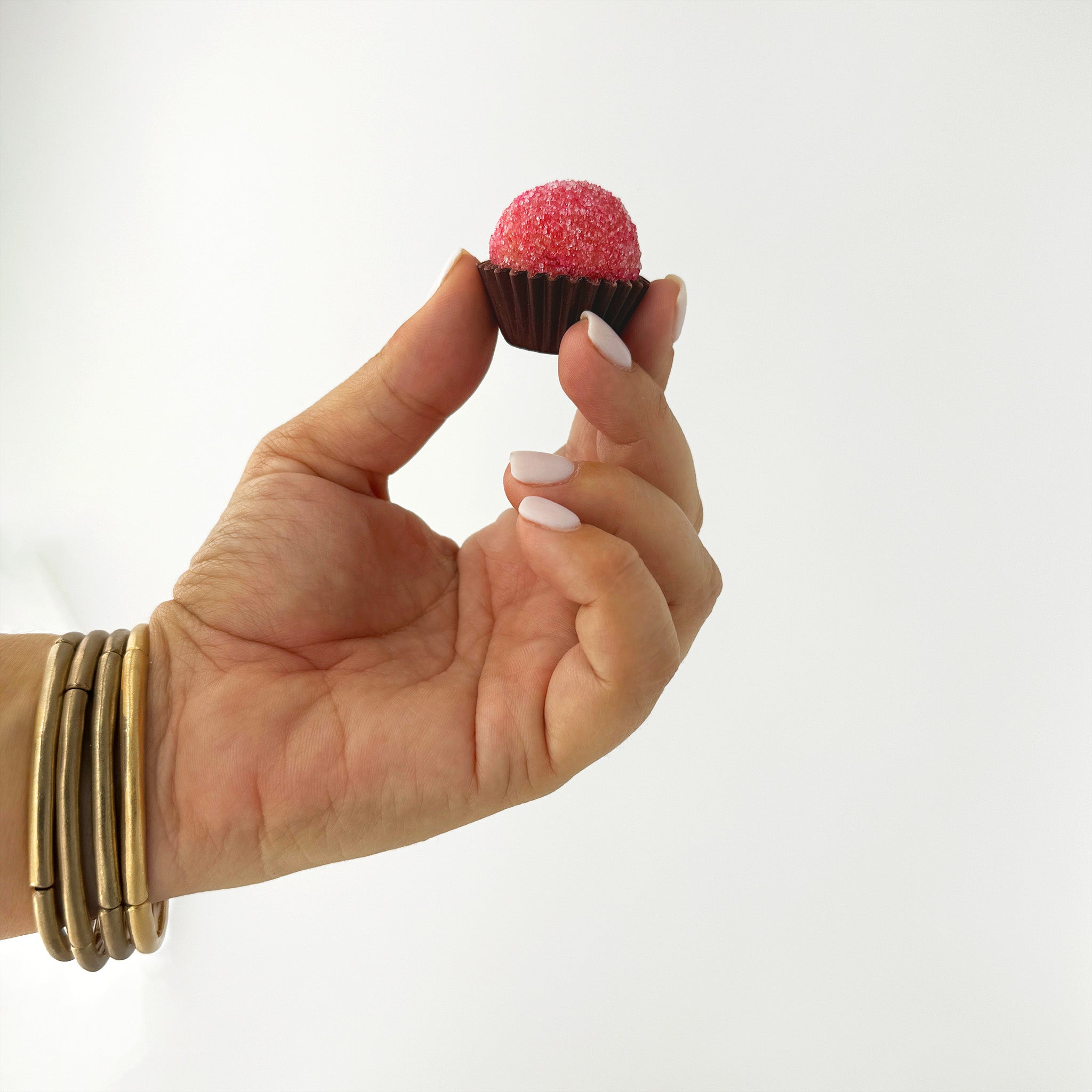 Hand holding a strawberry brigadeiro