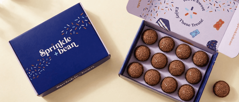 Open Sprinkle+Bean gift box with handcrafted Brazilian brigadeiros in brown paper cups — fresh brigadeiro delivery from Miami