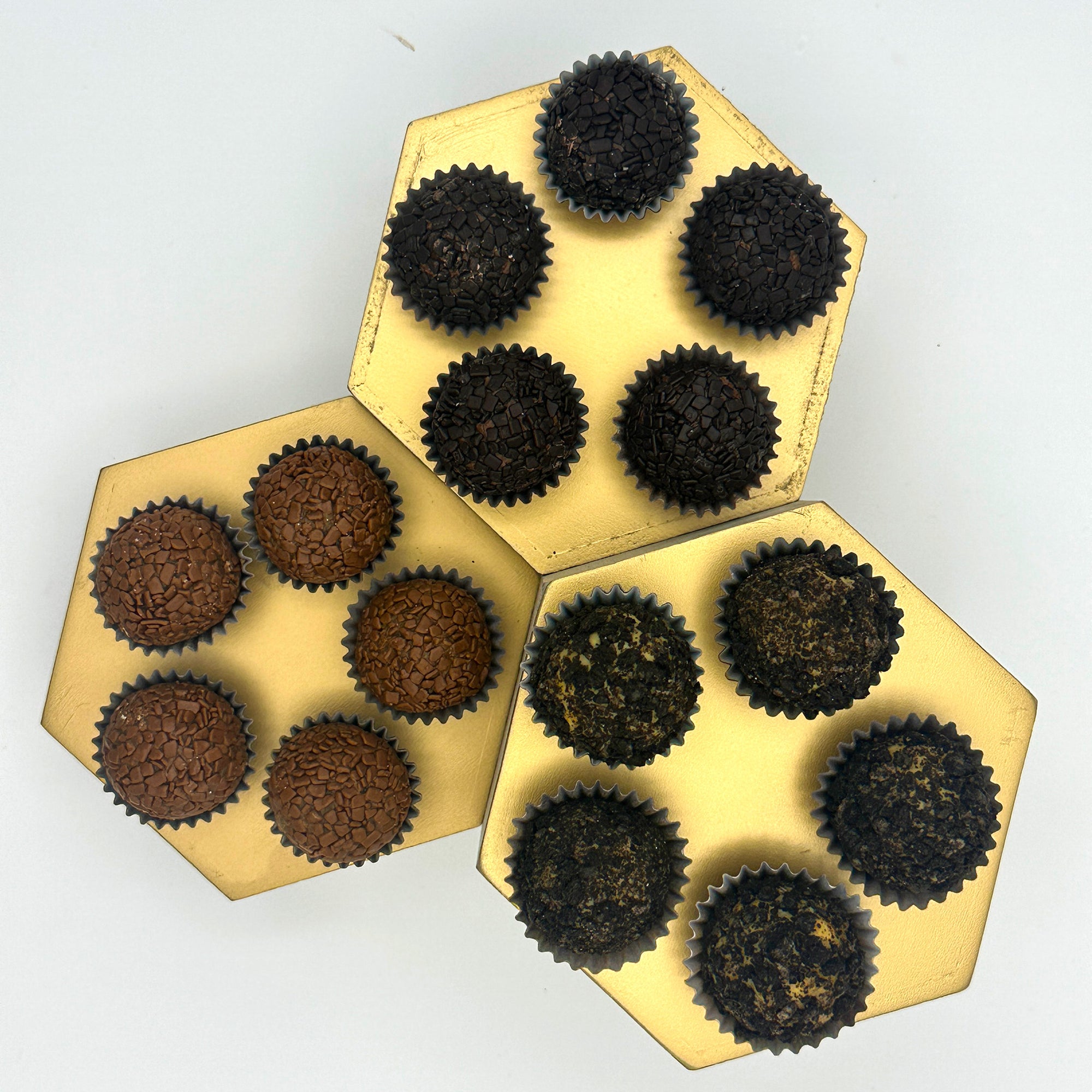 Four Anniversary Chocolate Lovers Brigadeiros, or brigadeiros, on a golden tray for chocolate lovers celebrating an anniversary.