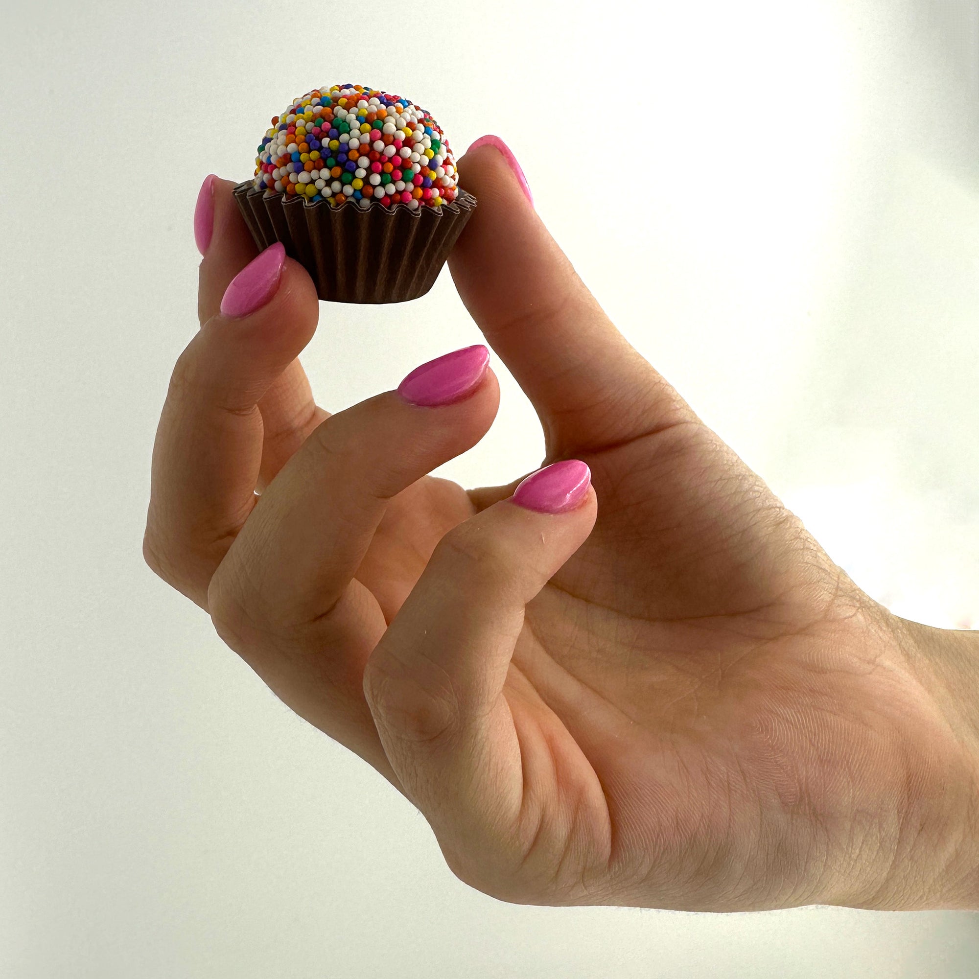 A person holding a Anniversary Classic Celebration Brigadeiro.